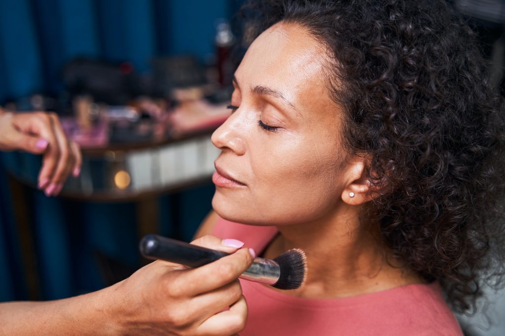 Portrait of relaxed woman doing professional makeup